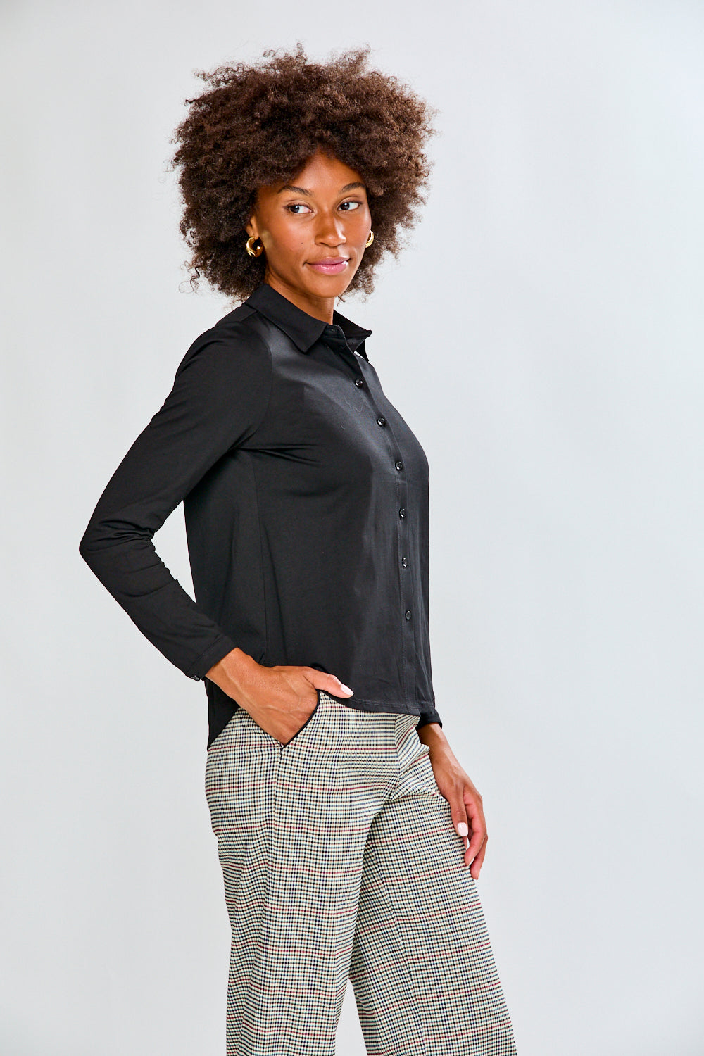 Woman wearing a black shirt and plaid pants on a white background