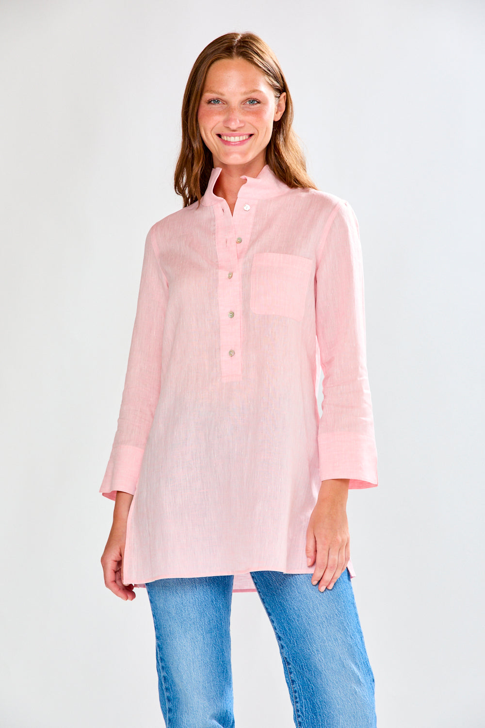 Woman wearing a sorbet shirt and blue jeans on a white background
