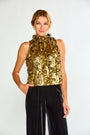 Woman wearing a gold metallic top and black pants on a white background