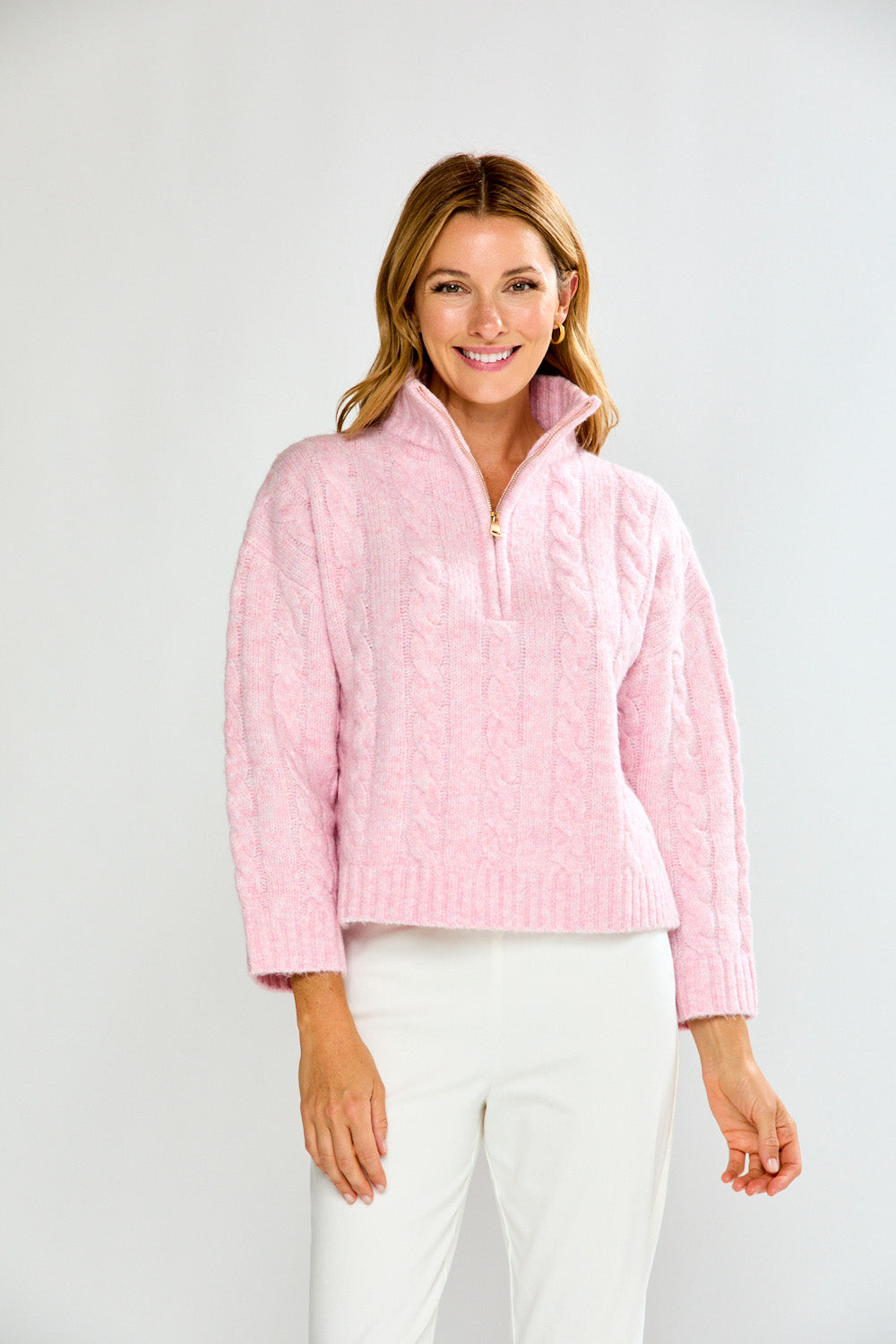 Woman wearing a pink pullover with a zipper on a white background