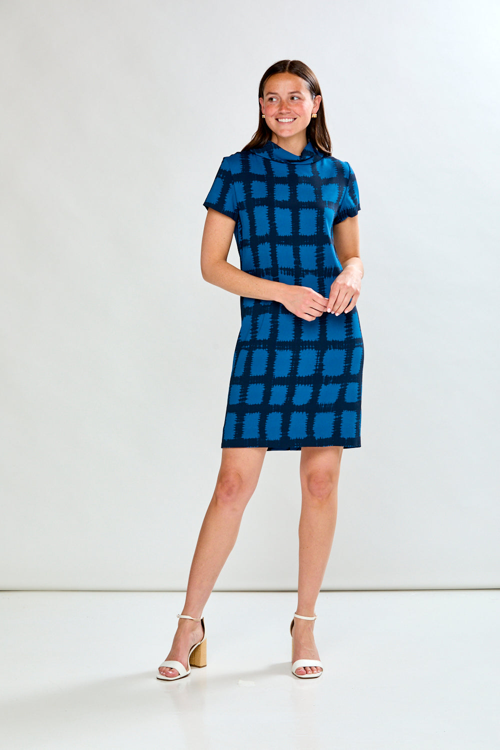 Woman wearing a blue checkered dress against a white background