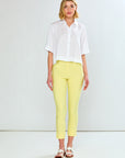 Woman wearing a white shirt and yellow pants against a white background