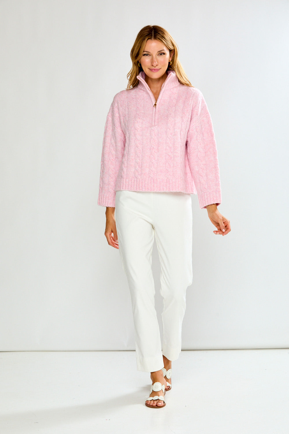 Woman wearing a pink pullover with a zipper on a white background