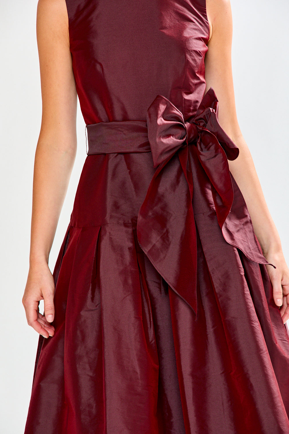 Maroon dress with a large bow detail on a white background
