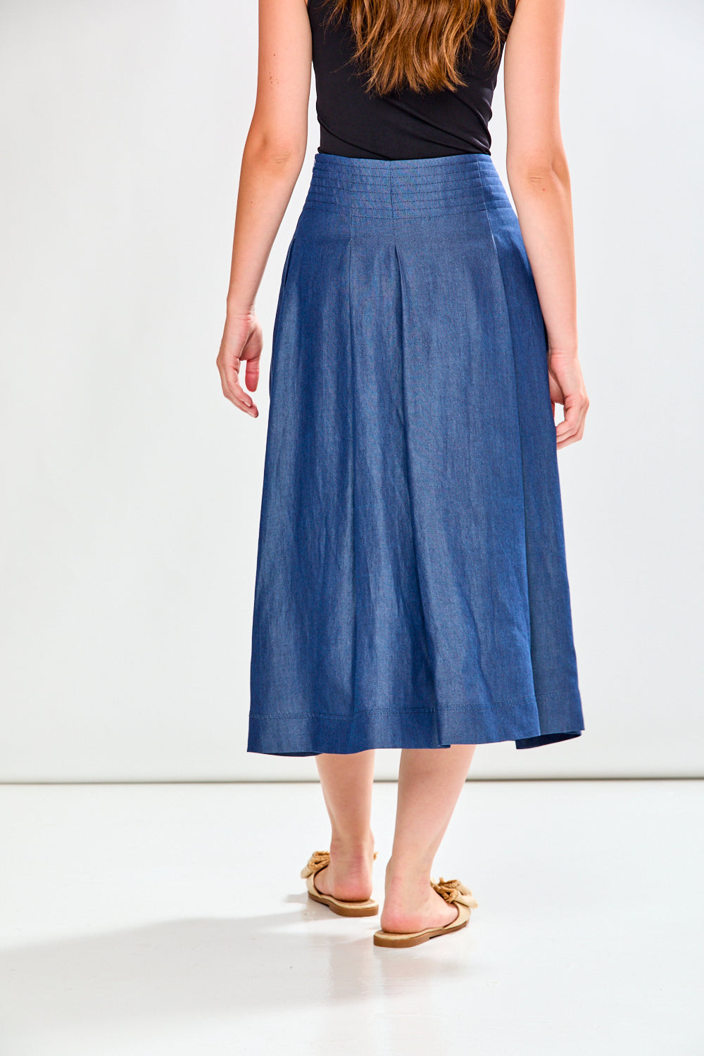 Woman wearing a blue denim skirt on a white background