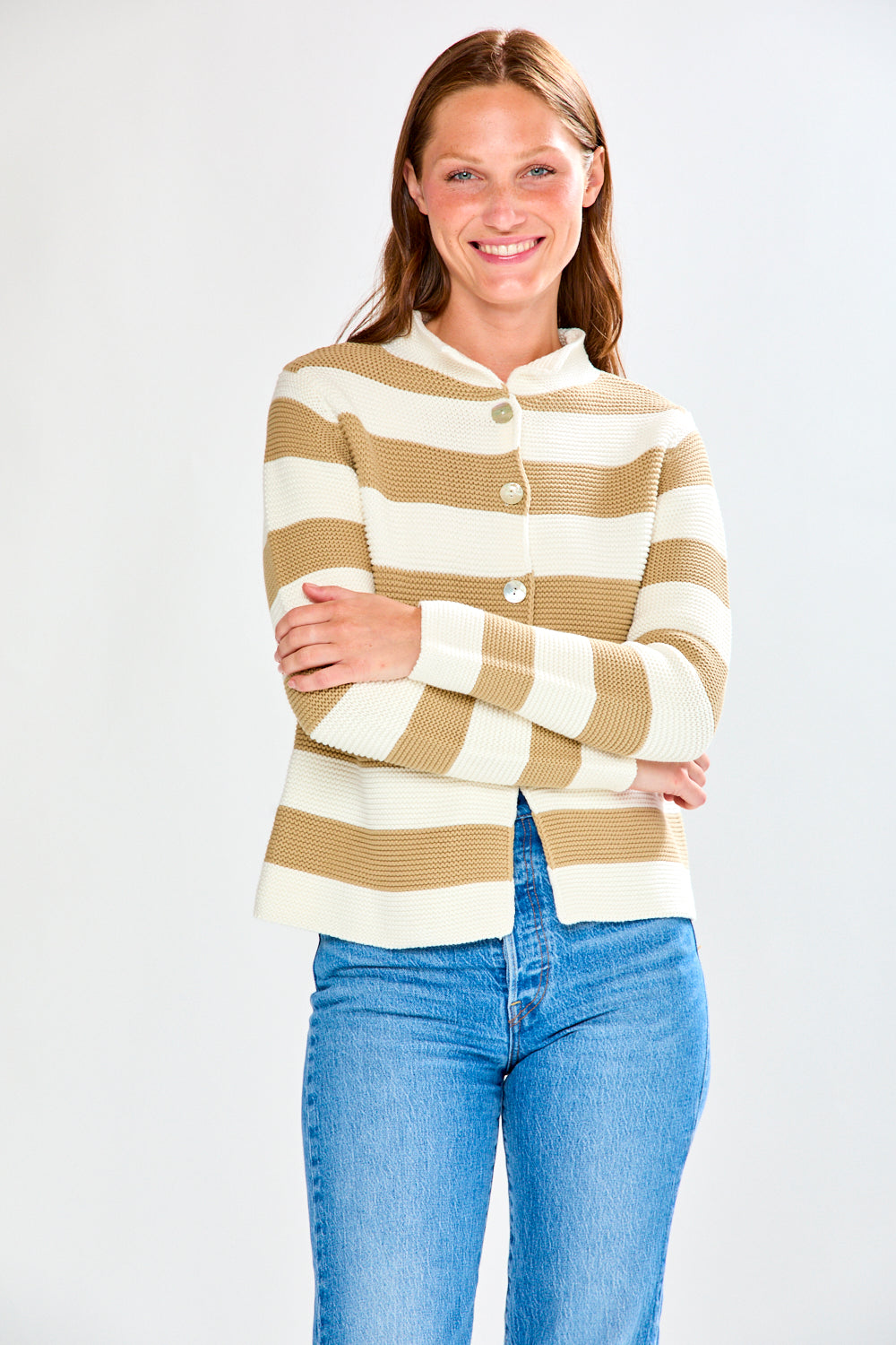 Woman wearing a striped sweater and jeans on a white background