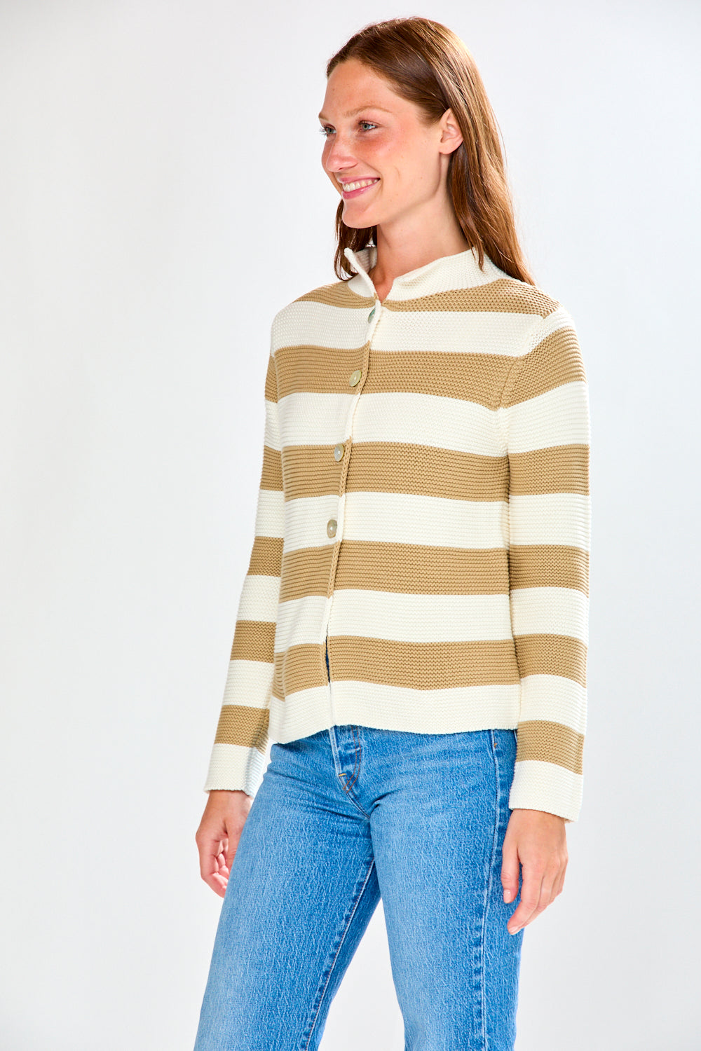 Woman wearing a striped sweater and blue jeans on a white background