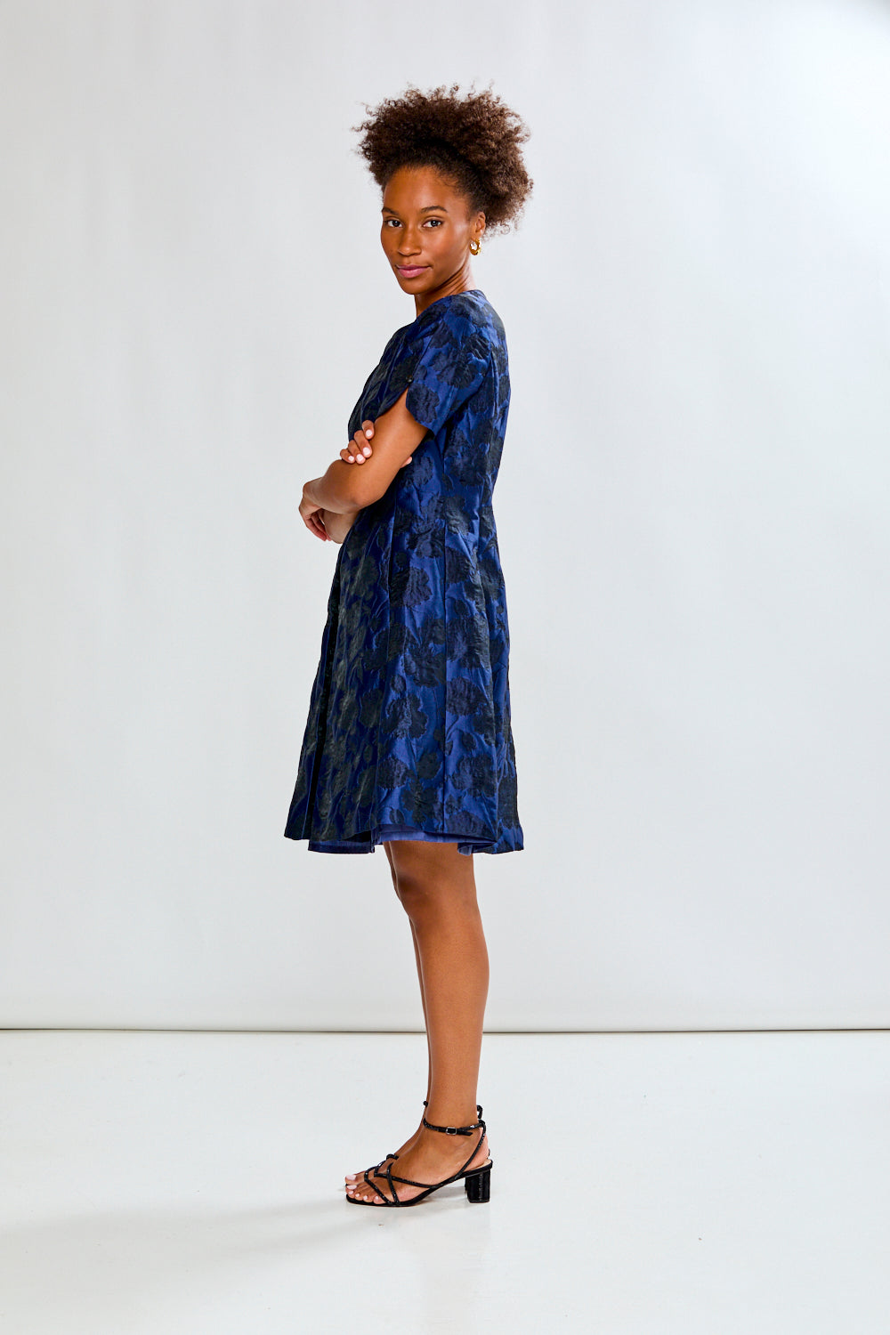 Woman wearing a blue floral dress against a white background