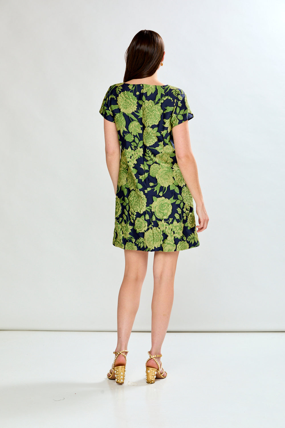 Woman wearing a green floral dress on a white background