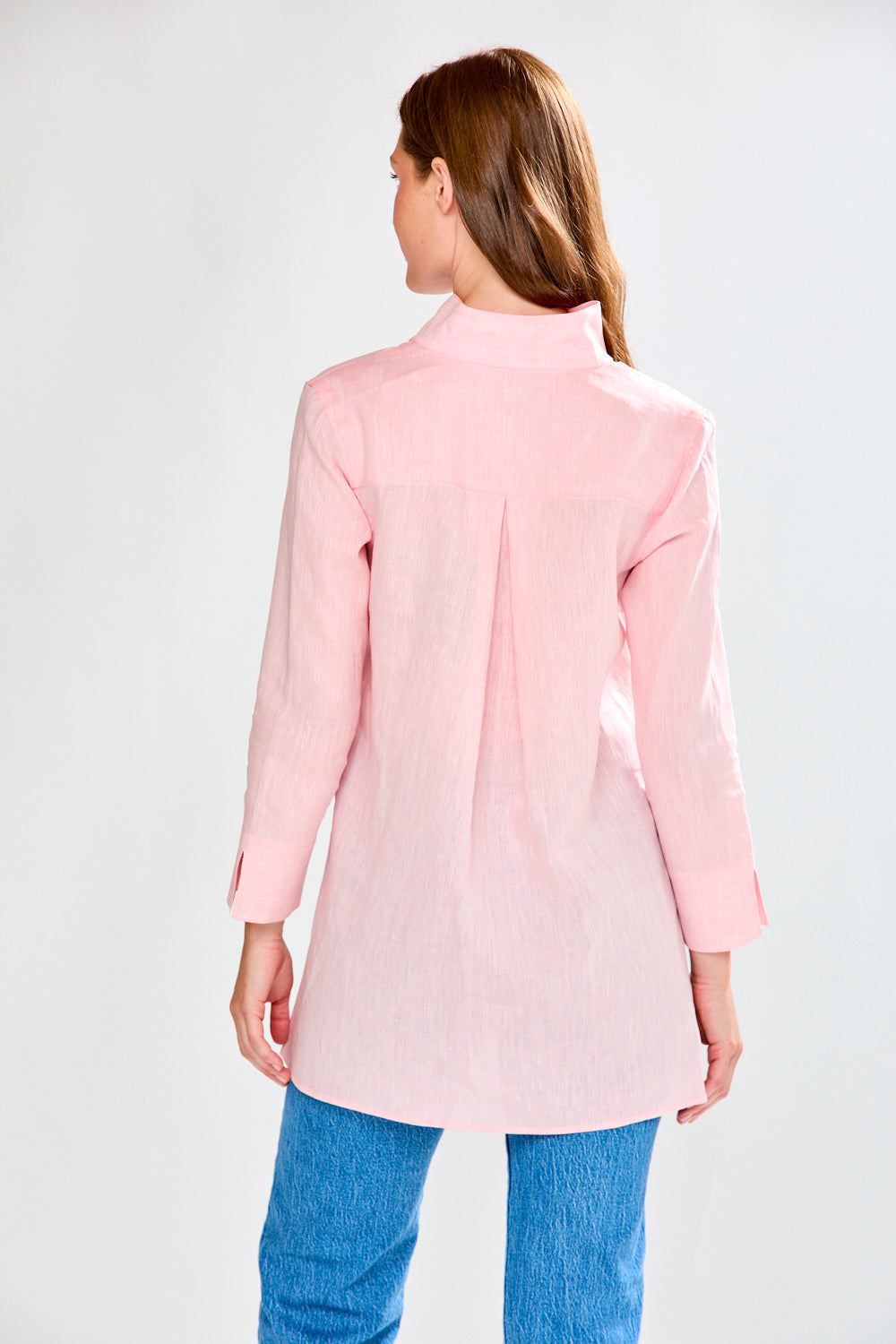 Woman facing backwards wearing a pink tunic