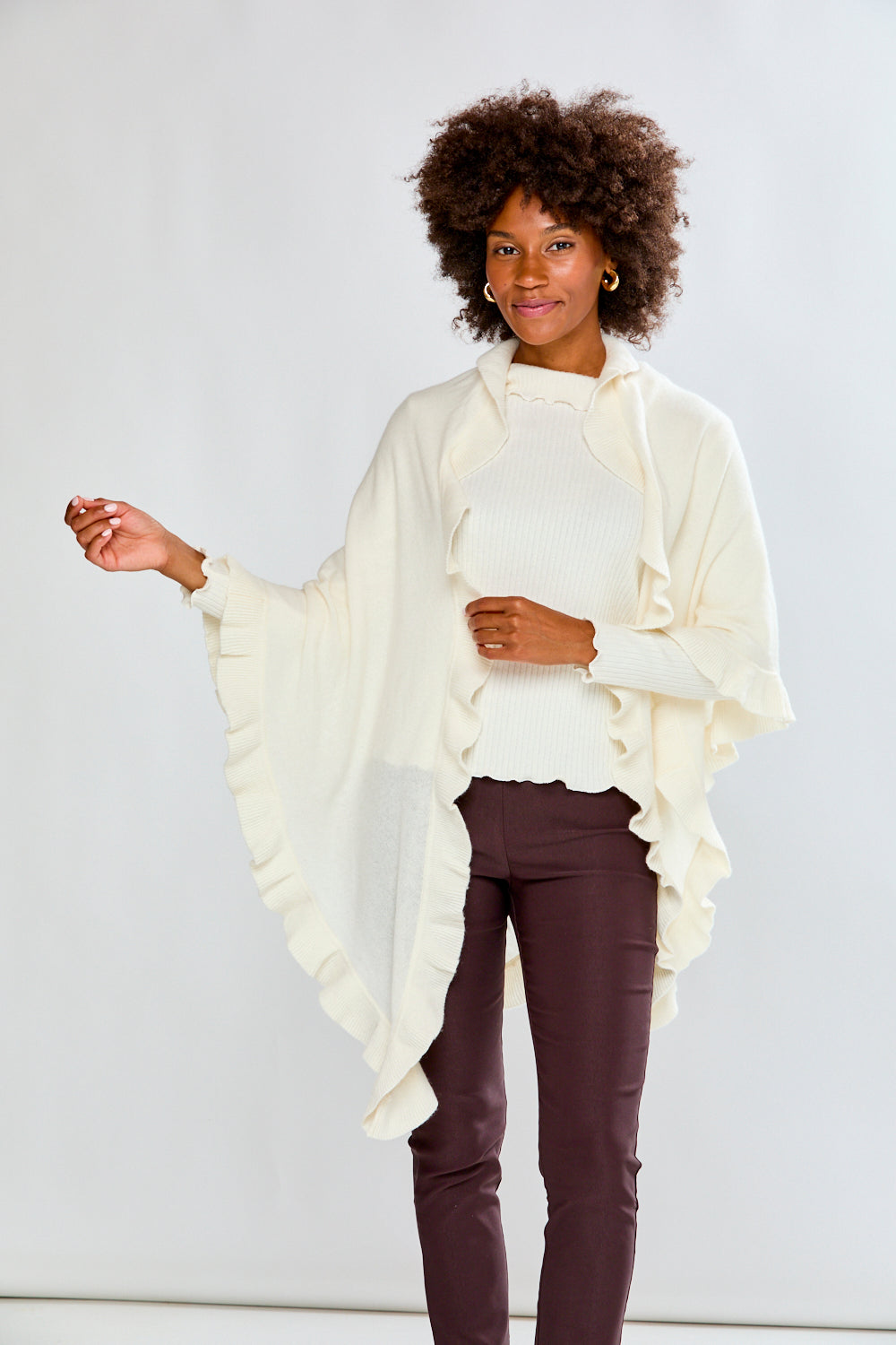 Woman wearing a white ruffled scarf against a plain background