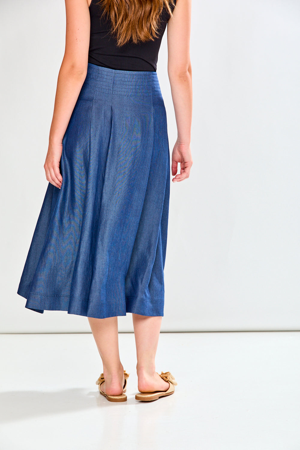 Person wearing a blue denim skirt on a white background