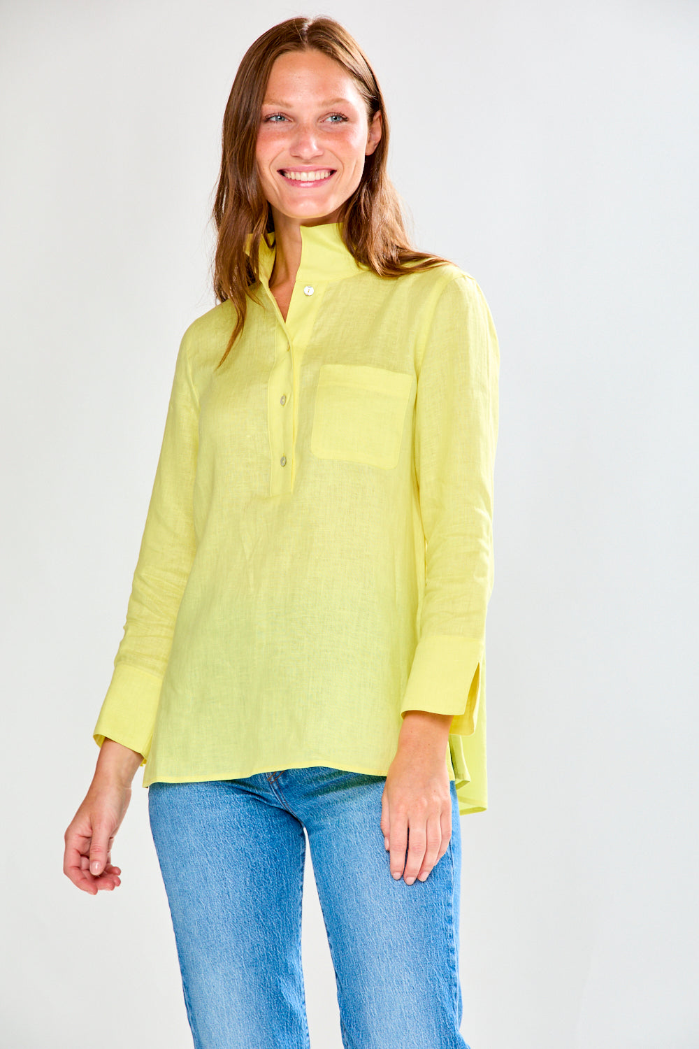 Woman wearing a sunflower and blue jeans against a white background