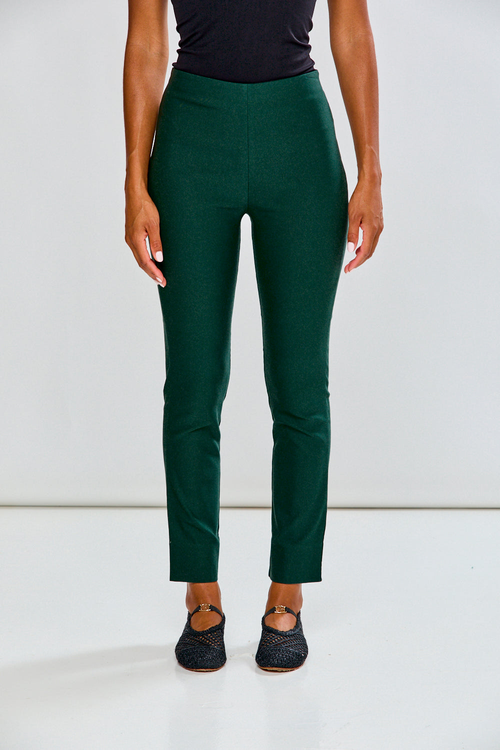 Person wearing evergreen pants on a white background