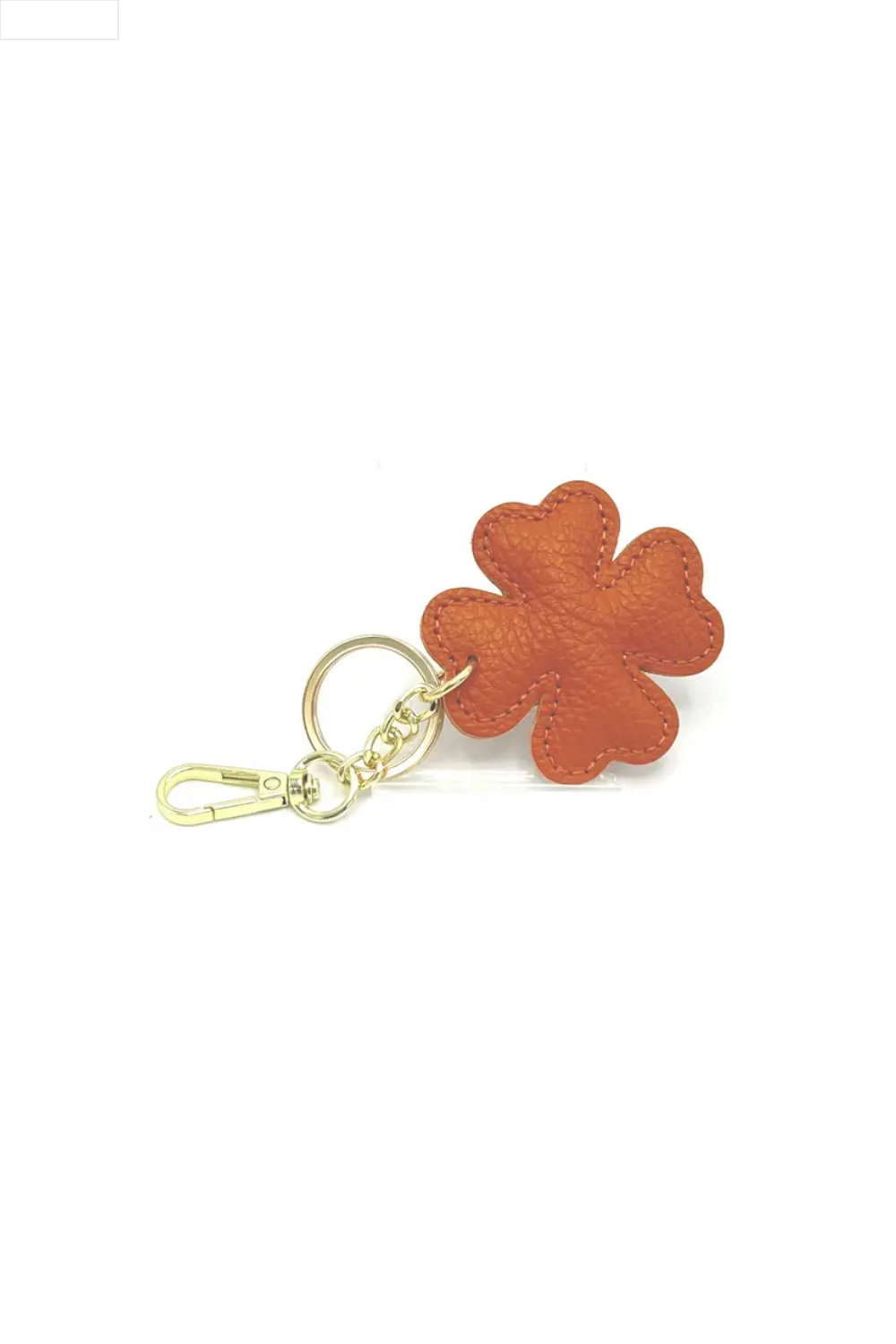 Orange four-leaf clover keychain on a white background