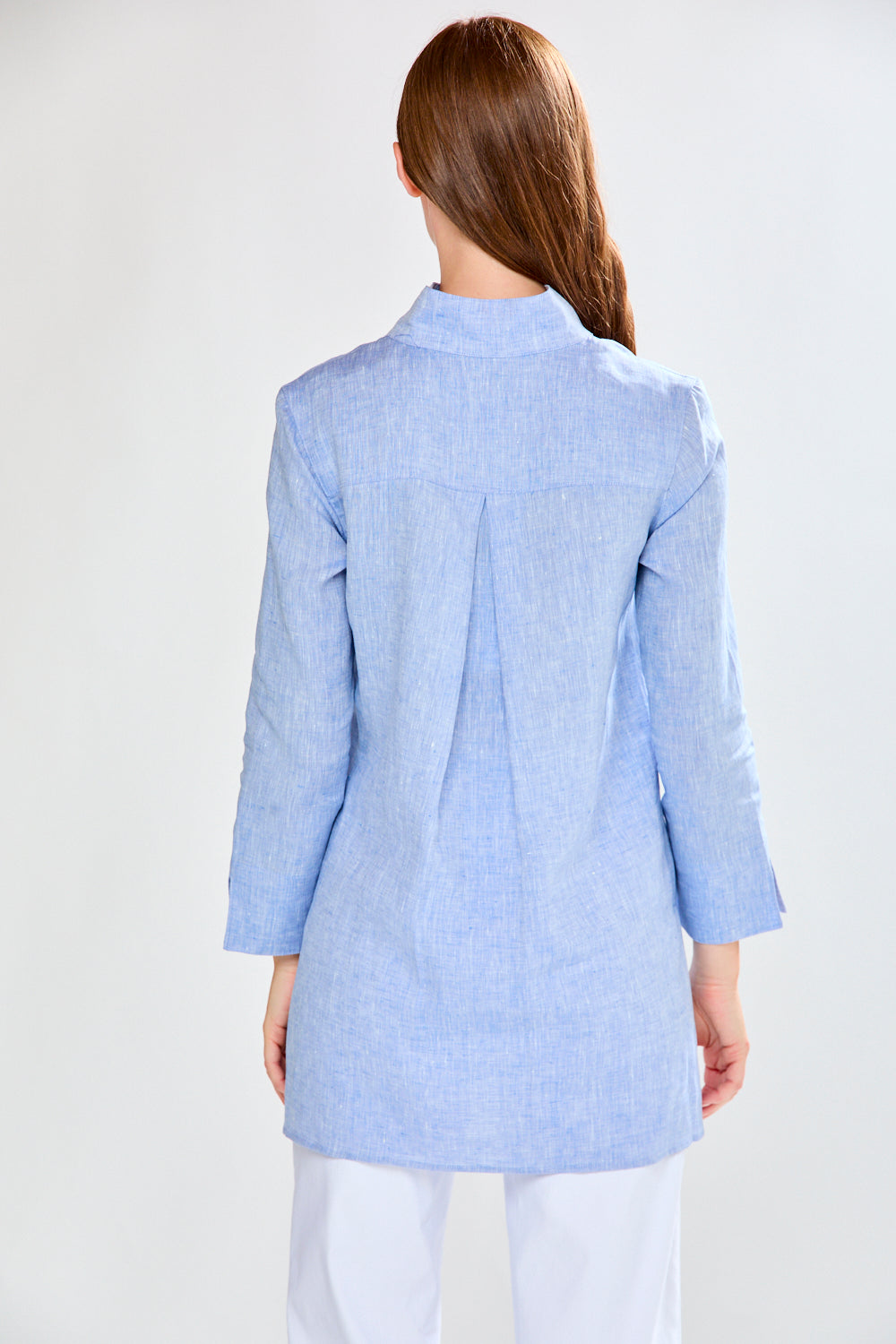 Woman wearing a light blue checkered blazer on a white background