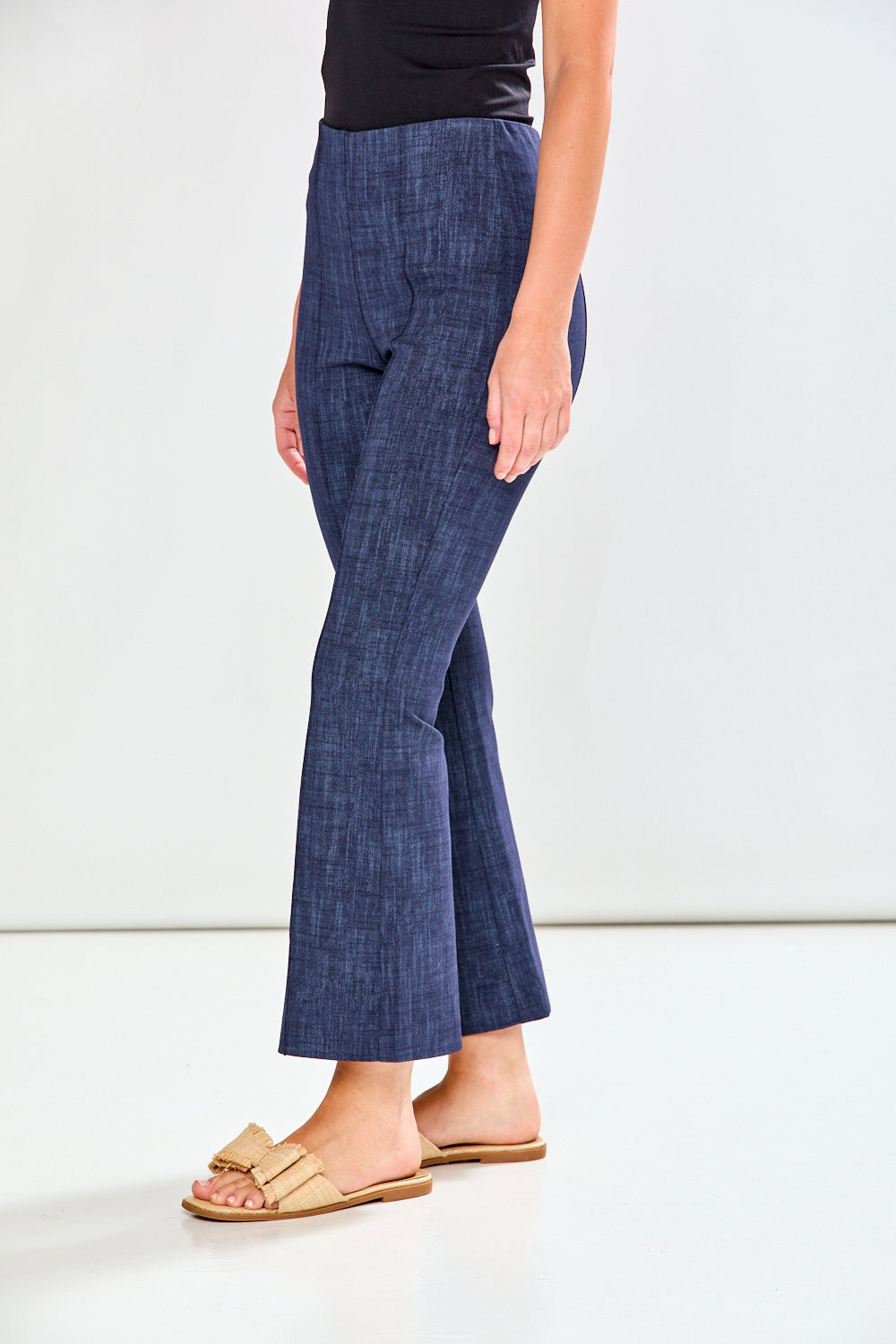 Person wearing blue flared pants on a white background