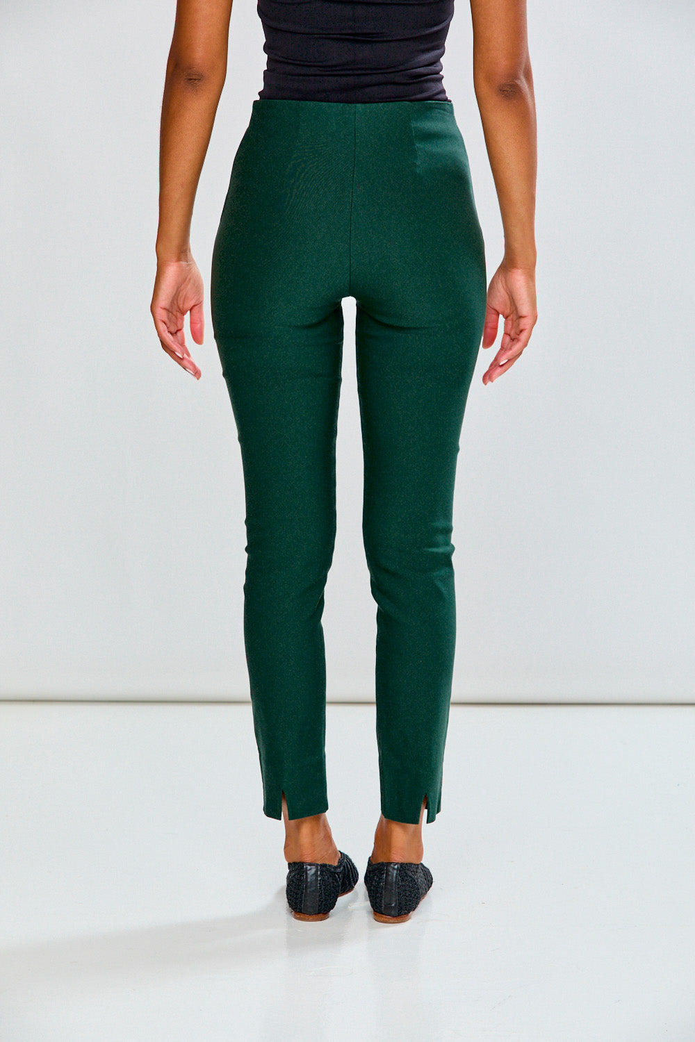 Person wearing evergreen pants on a white background