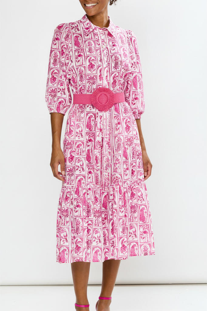 Woman wearing a pink and white patterned dress with a belt on a white background