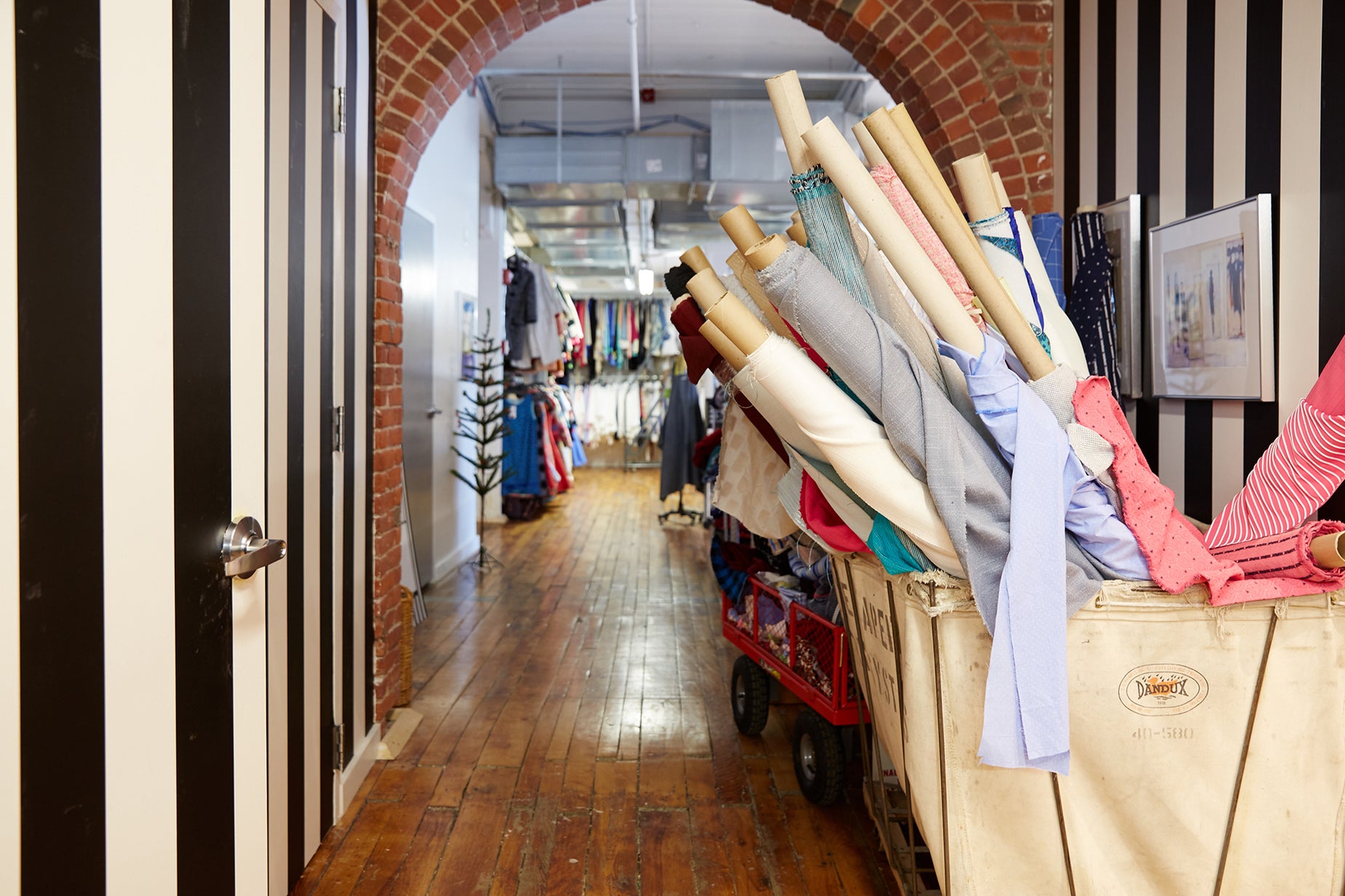 The Sara Campbell office, with rolls of fabric and racks of clothing.