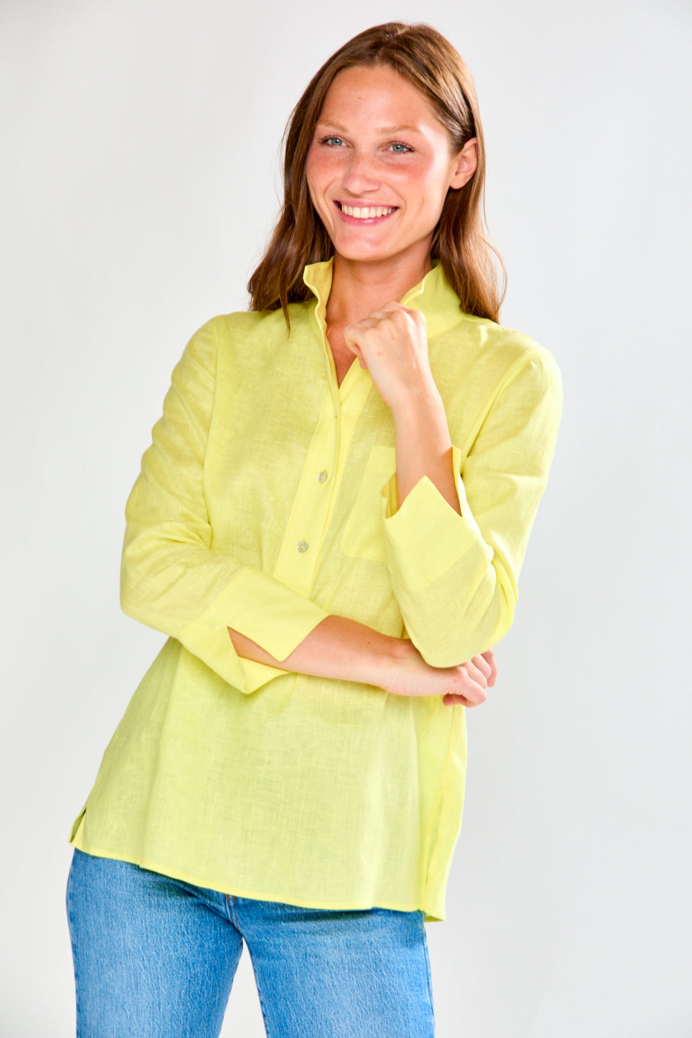 Woman wearing a sunflower and blue jeans against a white background