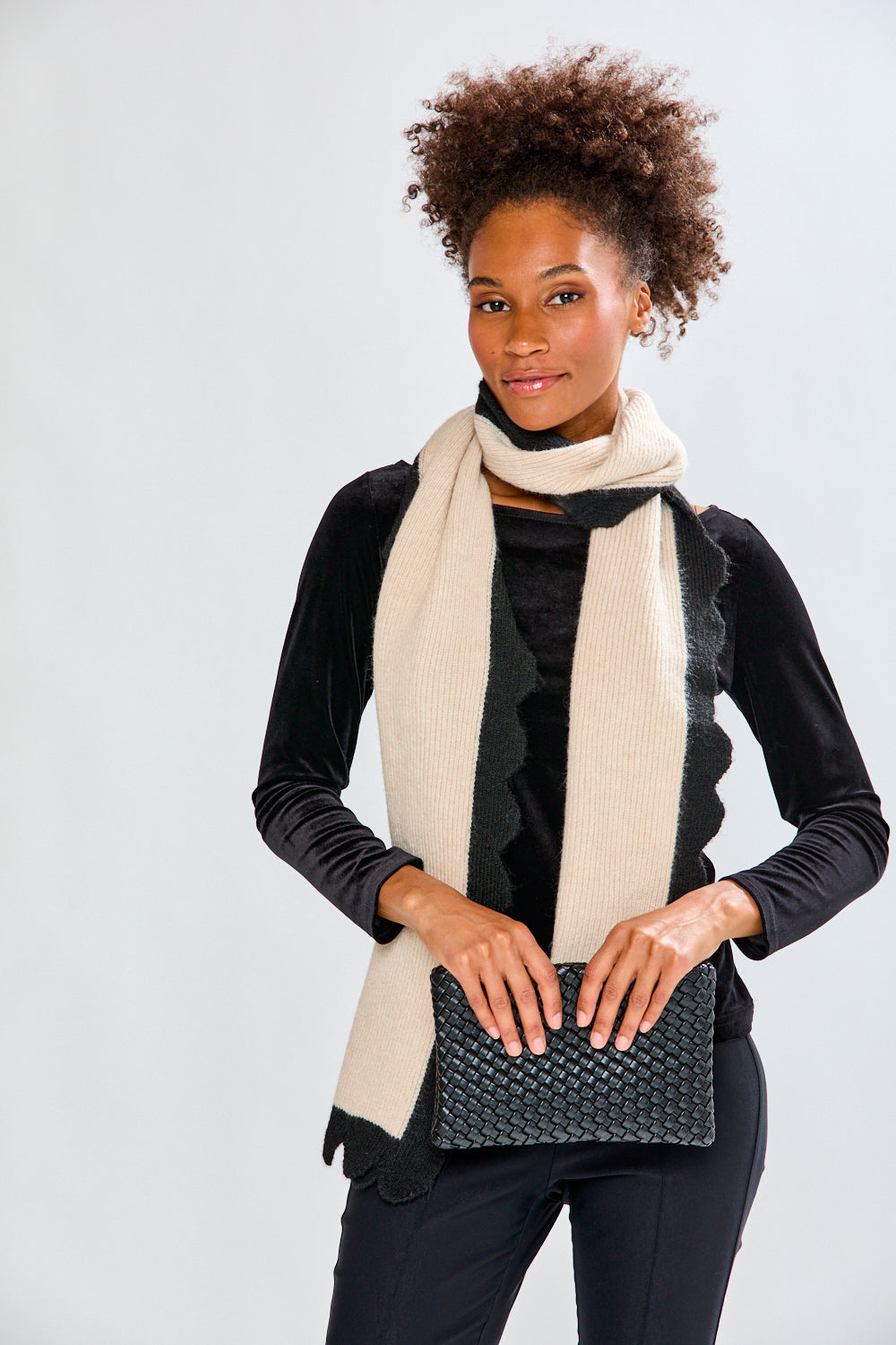 Woman holding black woven handbag