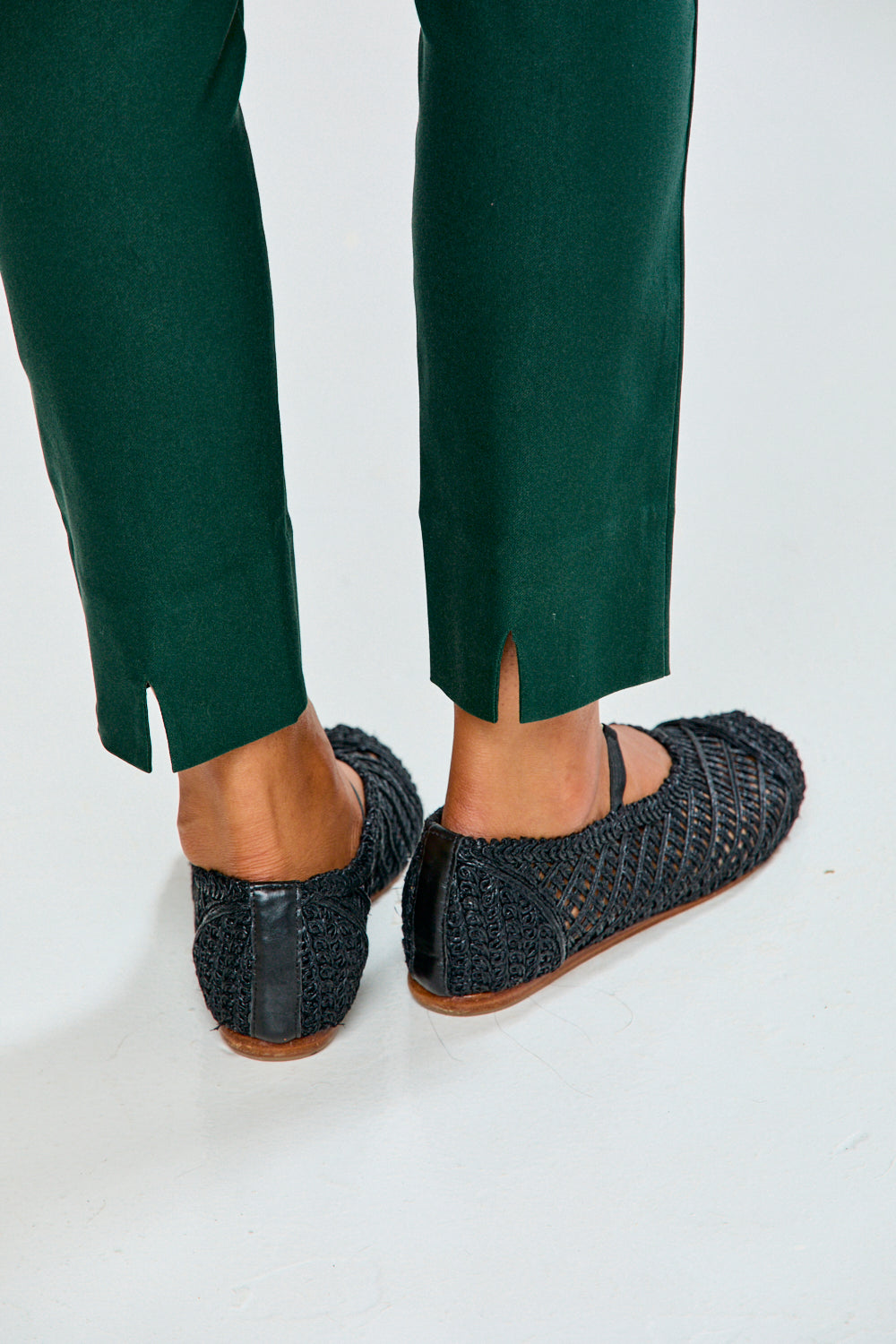 Person wearing evergreen pants on a white background