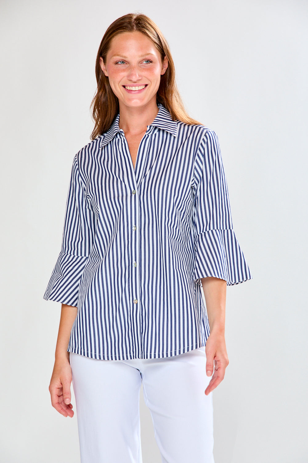 Woman wearing a blue and white striped shirt with a plain background
