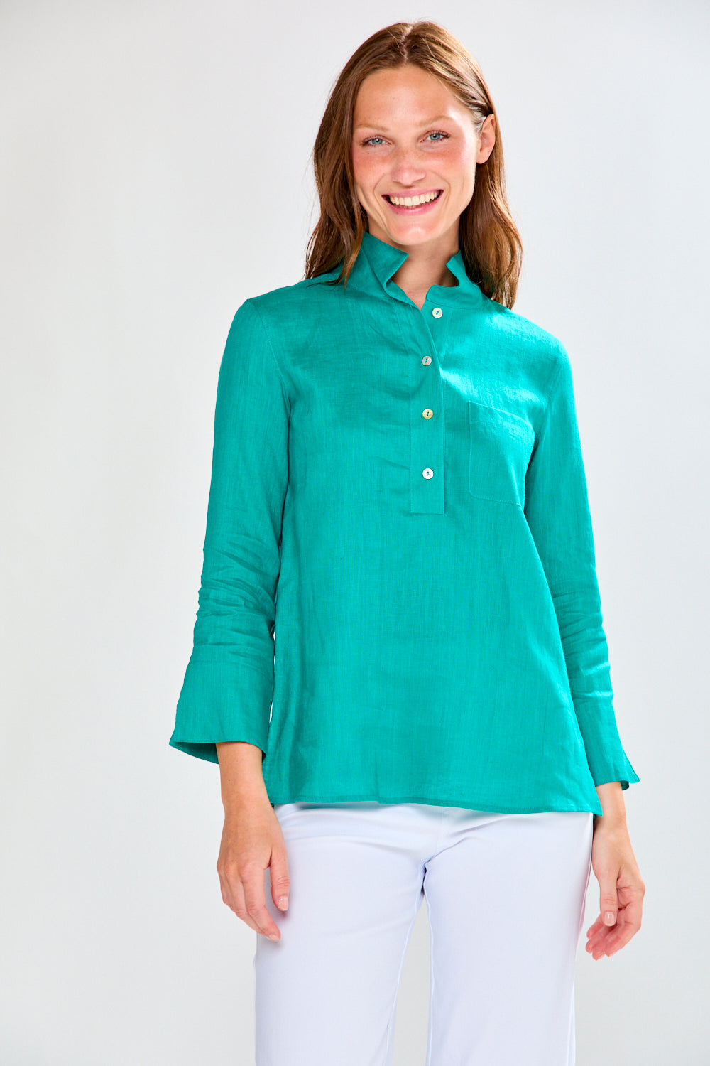 Woman wearing a teal blouse with a white background