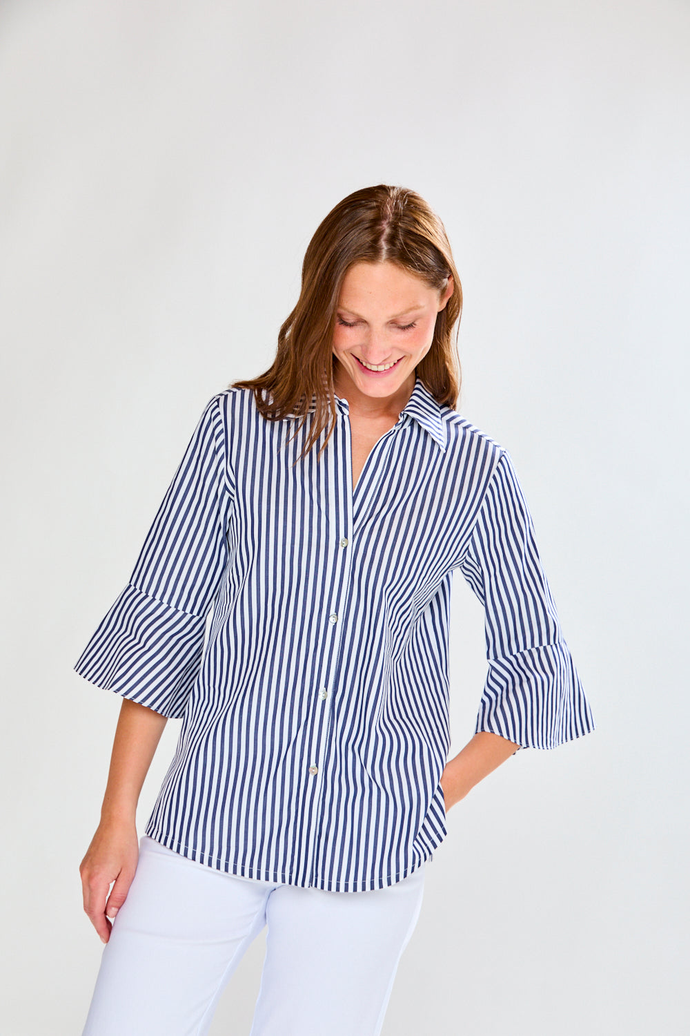 Woman wearing a blue and white striped shirt against a plain background