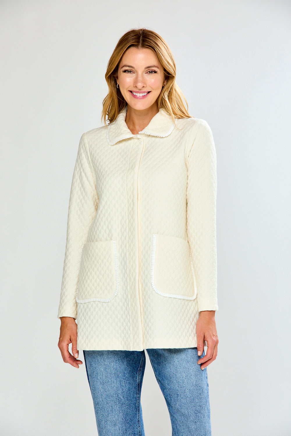 Woman wearing a cream quilted jacket on a white background