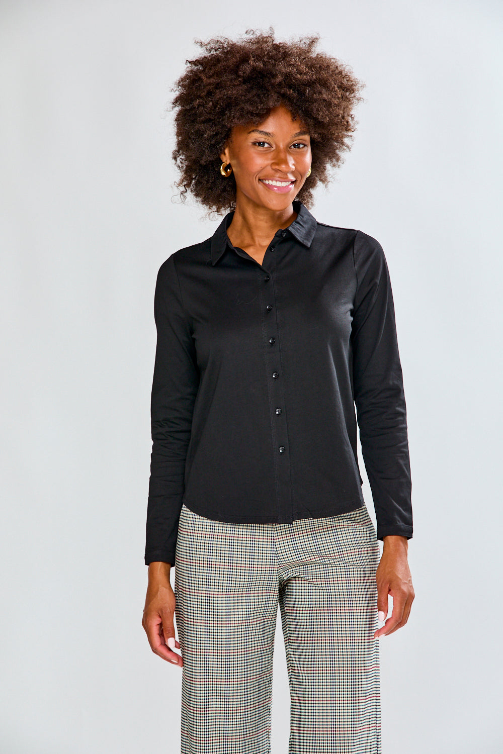 Woman wearing a black shirt and plaid pants on a white background