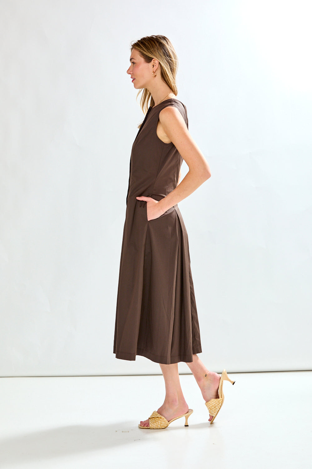 Woman wearing a brown sleeveless dress on a white background