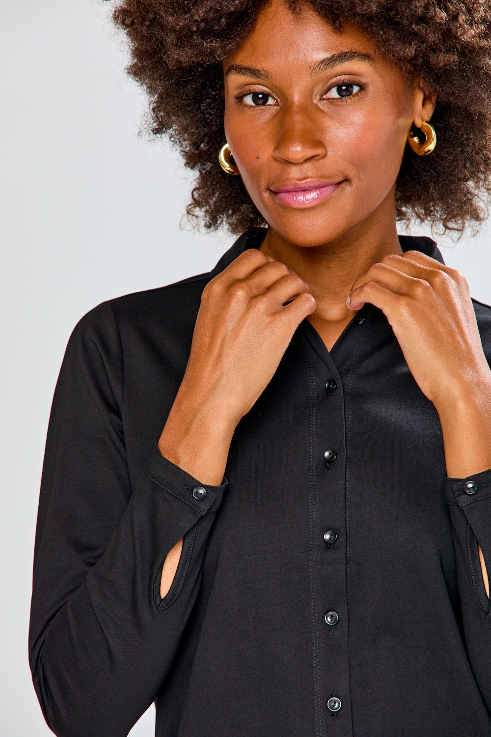 Woman wearing a black shirt and plaid pants on a white background