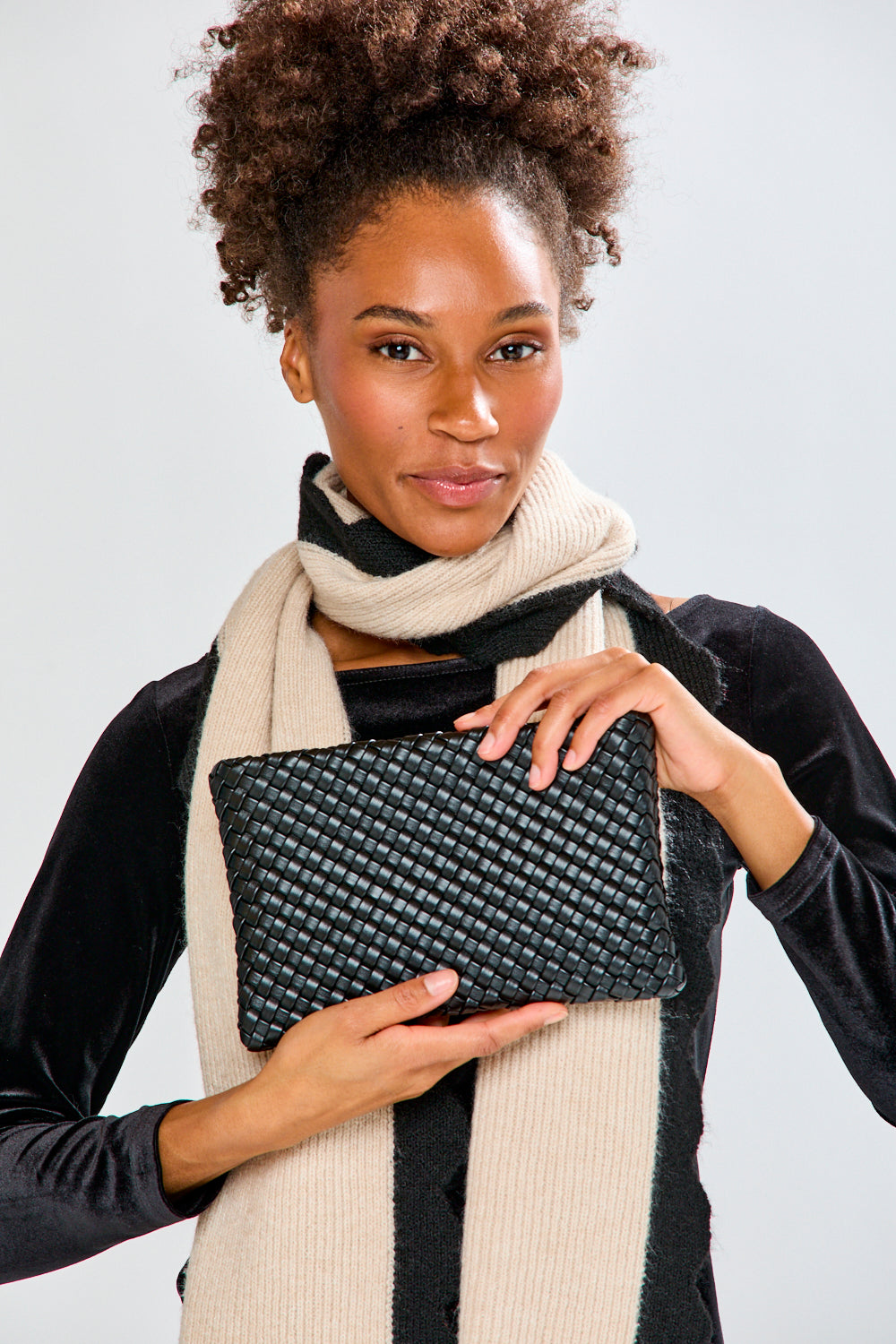 Woman holding black woven handbag