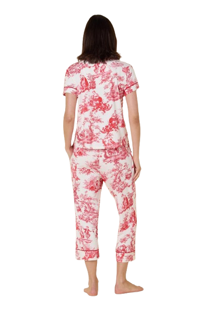 Woman wearing a pink and white toile pajama set on a white background