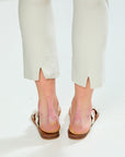 Person wearing beige pants and brown sandals on a white background