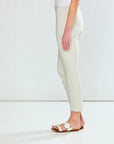 Person wearing white pants and sandals on a plain background