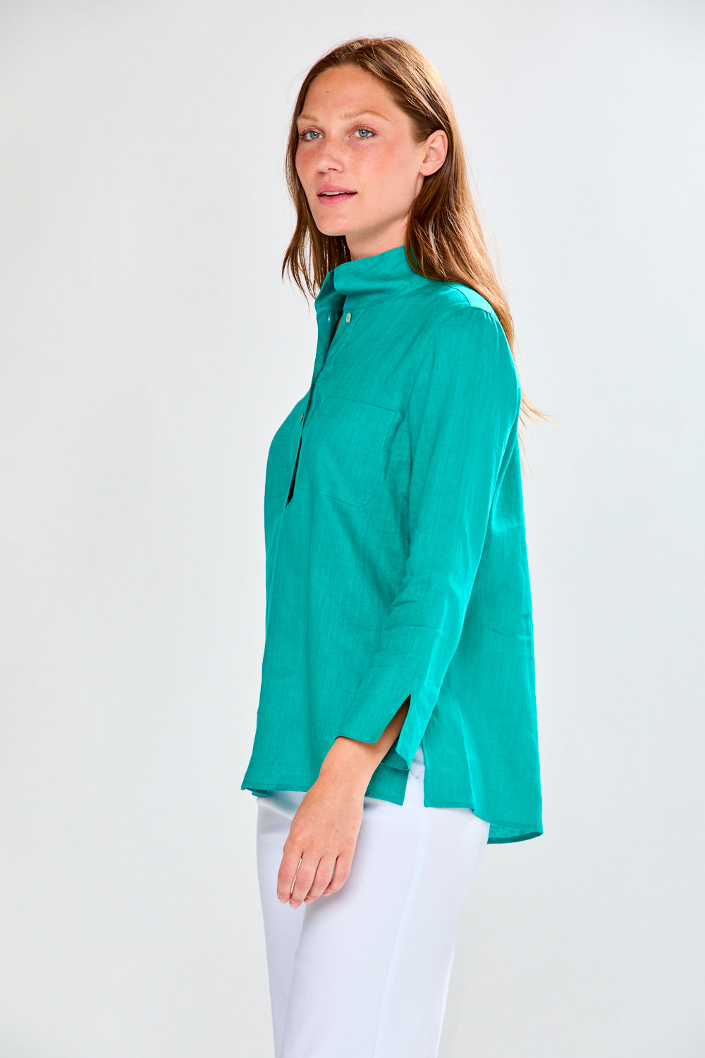 Woman wearing a teal blouse with a white background