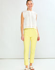 Woman wearing a white blouse and yellow pants against a white background