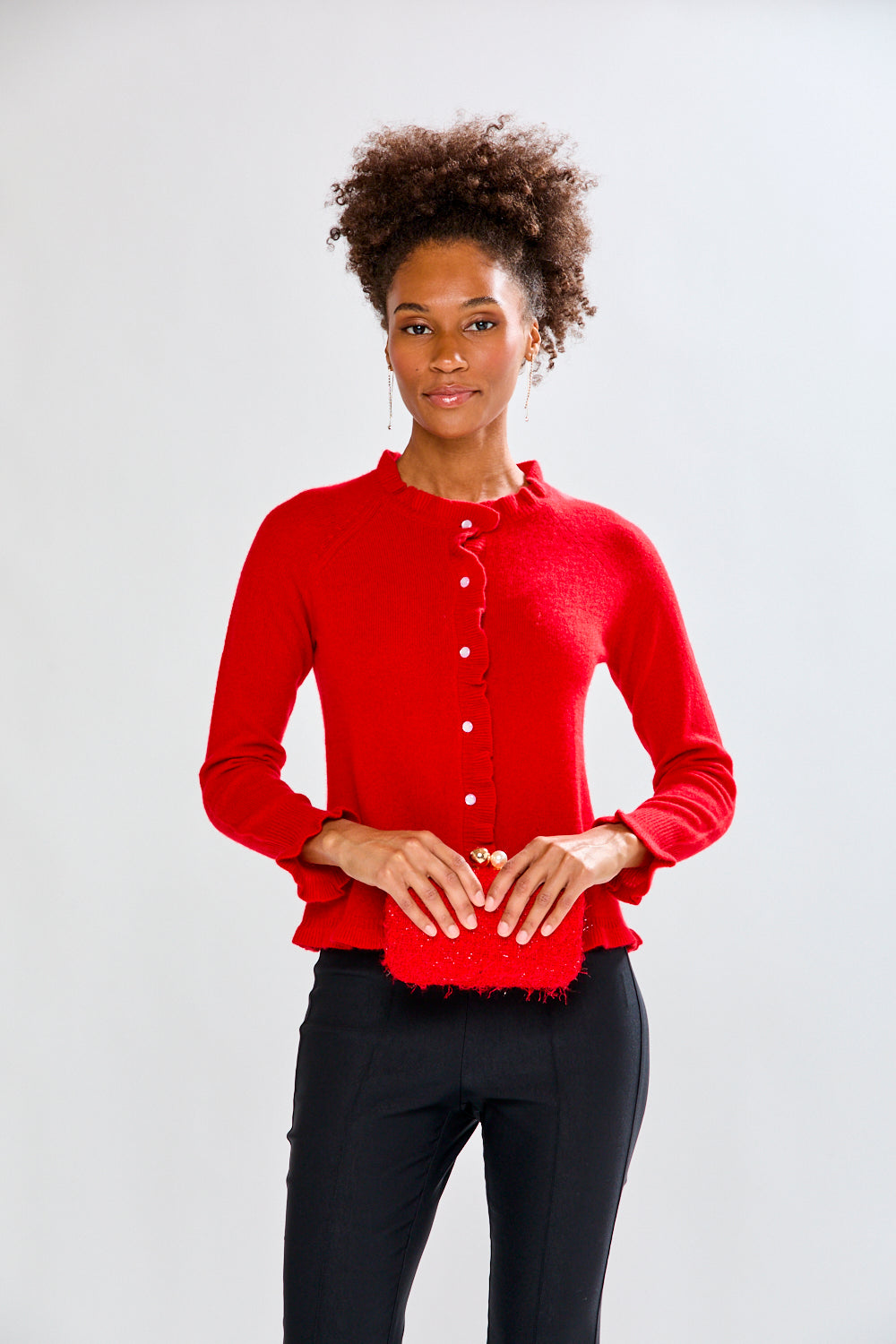 Woman holding a red clutch against a white background