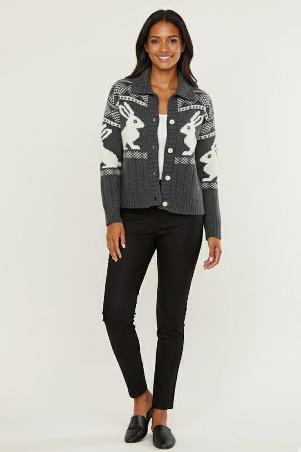 Woman wearing a patterned cardigan with black pants on a white background