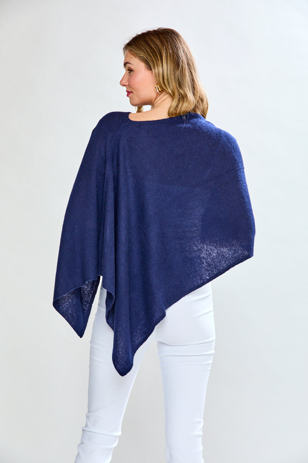 Woman wearing a blue poncho over a white background