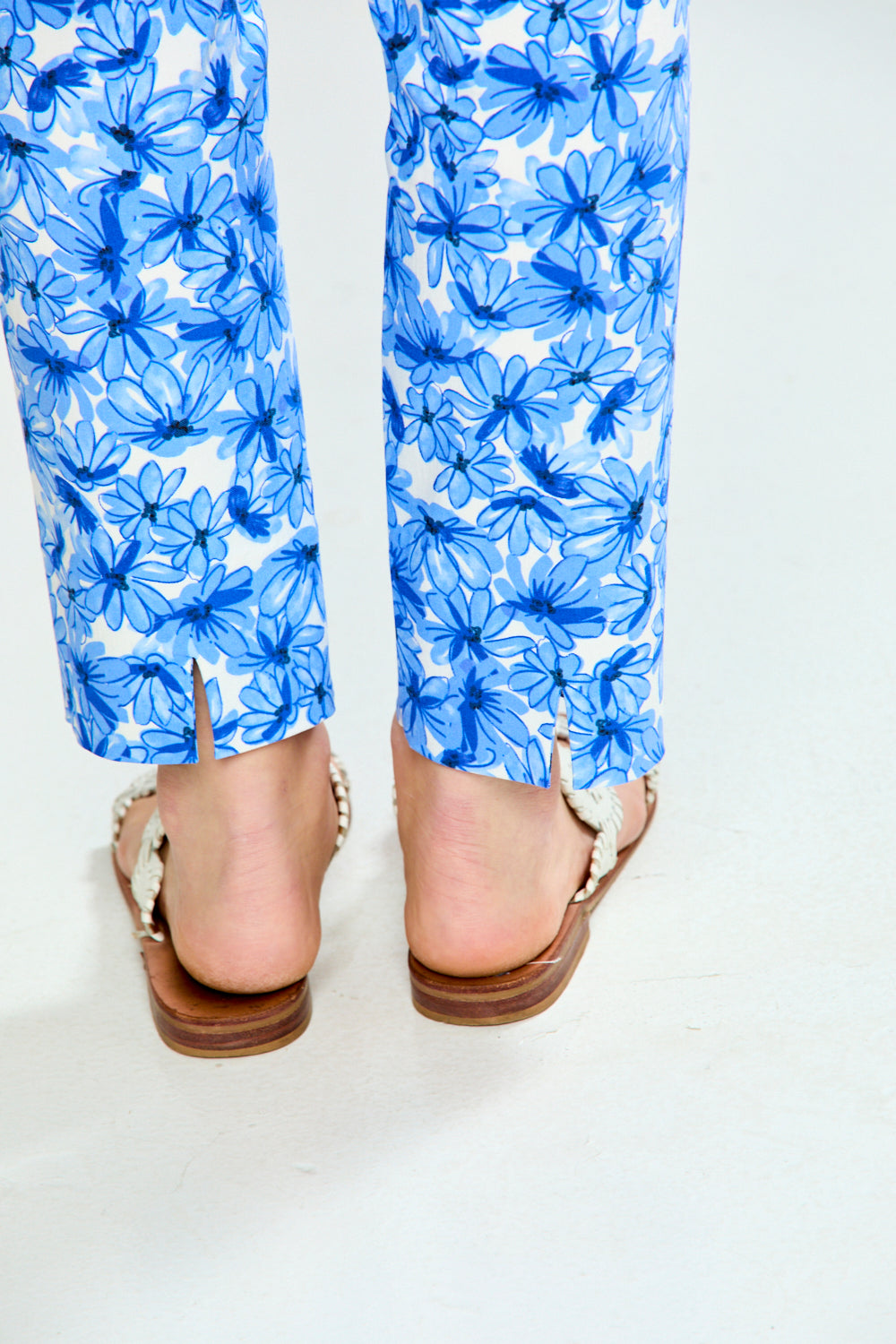 Blue floral pants worn by a person on a white background