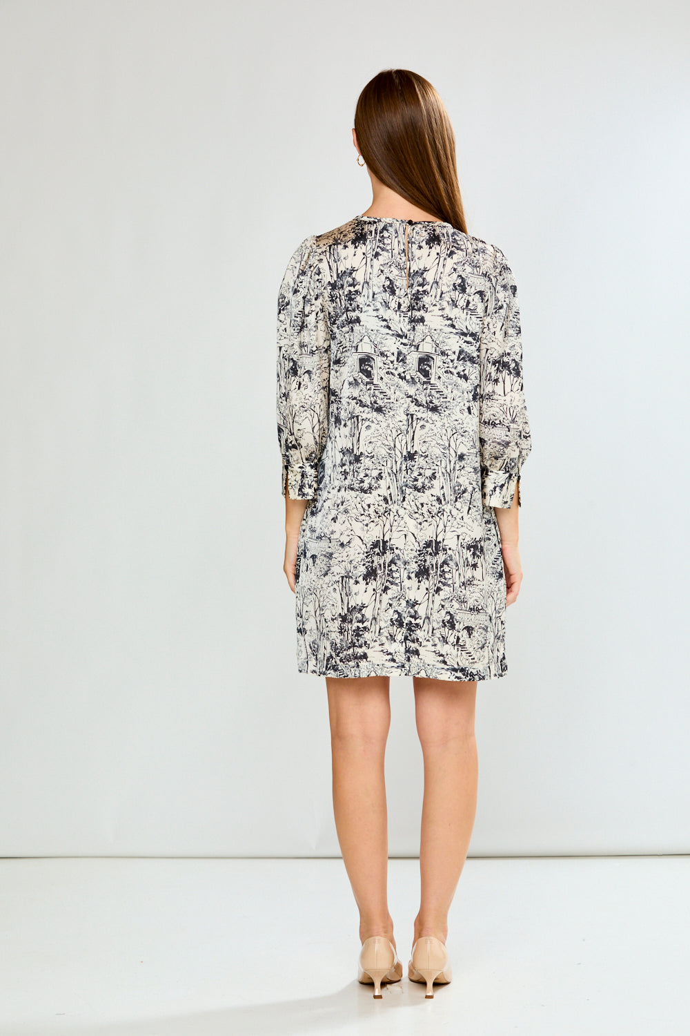 Woman wearing a patterned dress on a white background