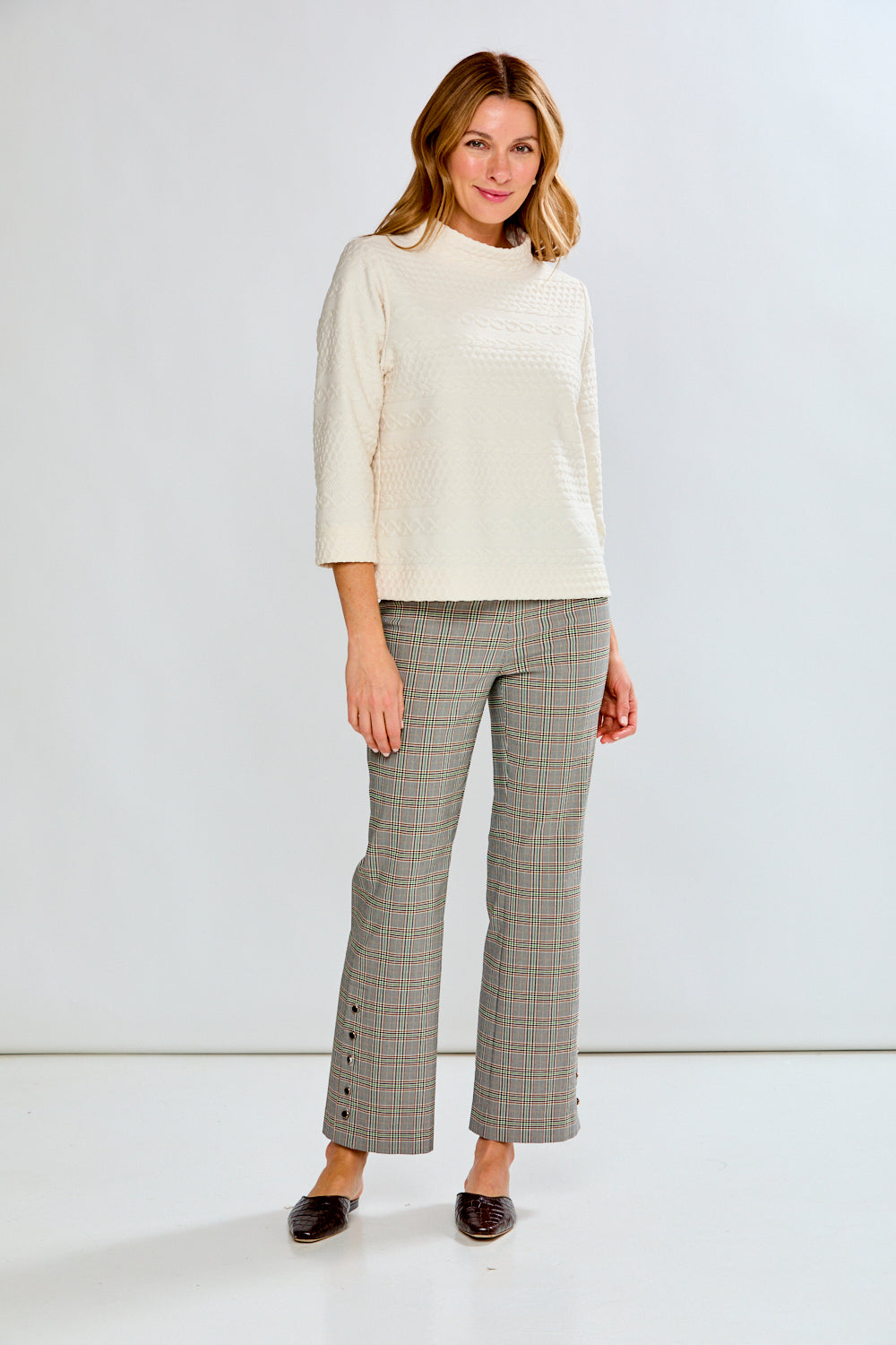 Person wearing plaid pants on a white background