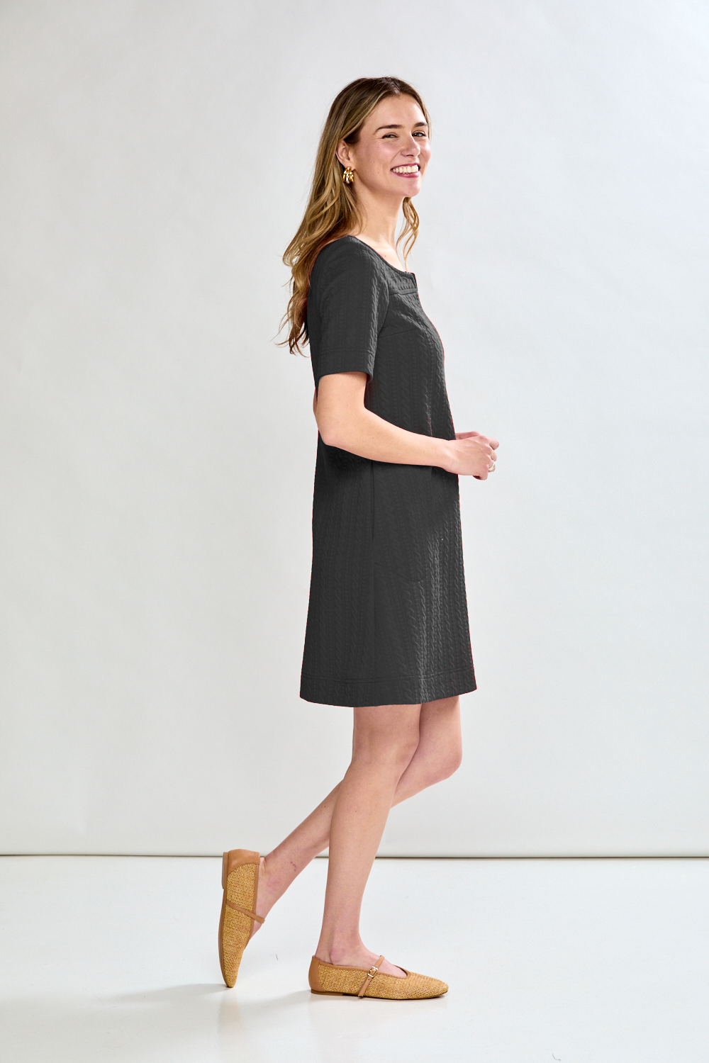 Woman wearing a black dress against a white background