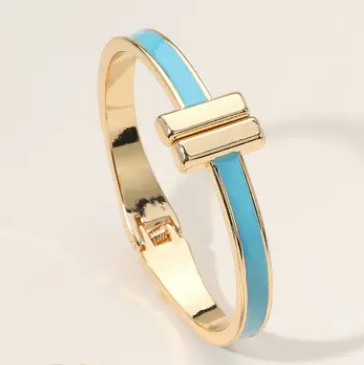 Gold bracelet with a blue band on a light background