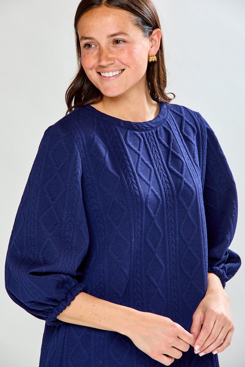 Woman wearing a blue dress with puffed sleeves on a white background