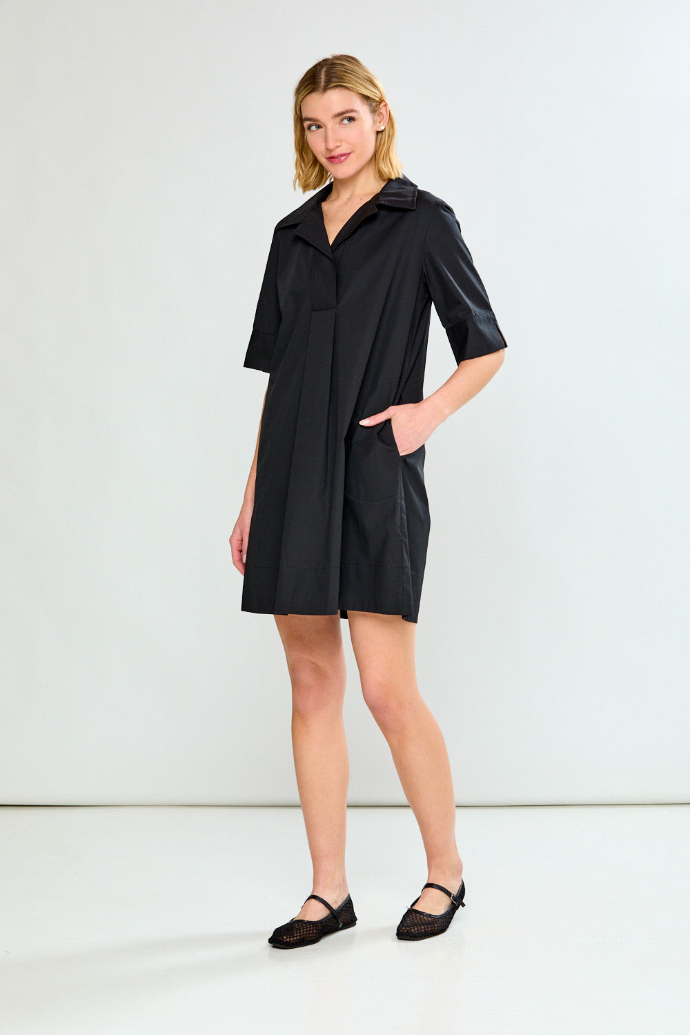 Woman wearing a black dress against a white background